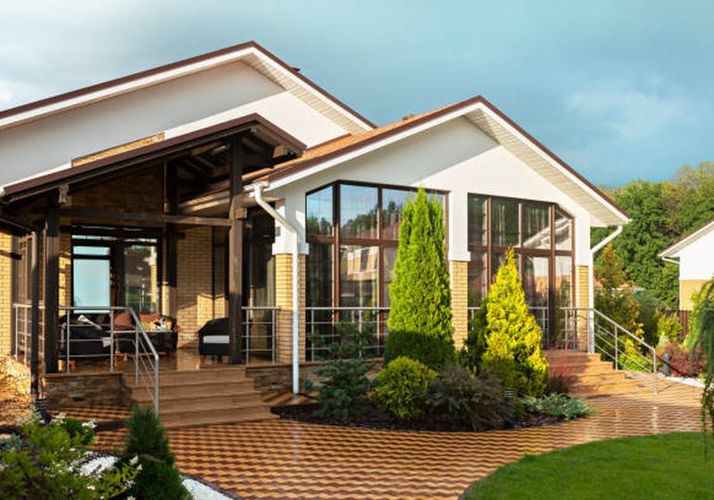 Modern home exterior with landscaped garden, lawn and pathway lighting